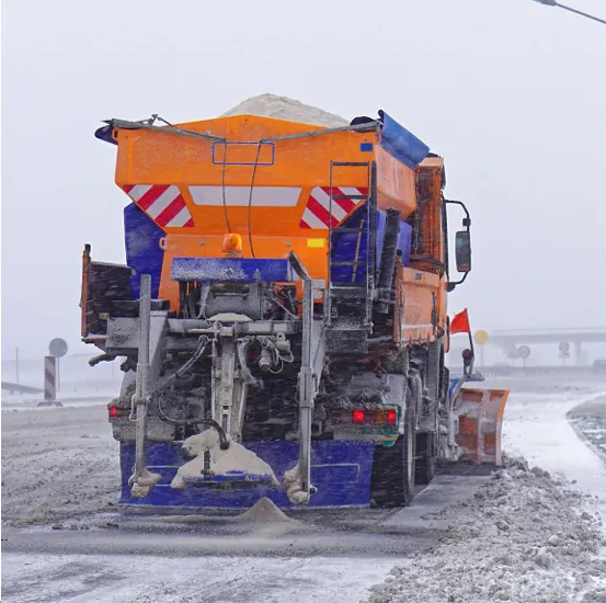 Gritting truck spreading de-icing salt on a snowy road