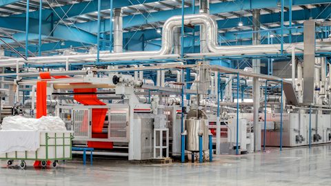 Industrial processing hall with machinery and ducting