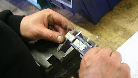 Measuring a metal part with a digital caliper