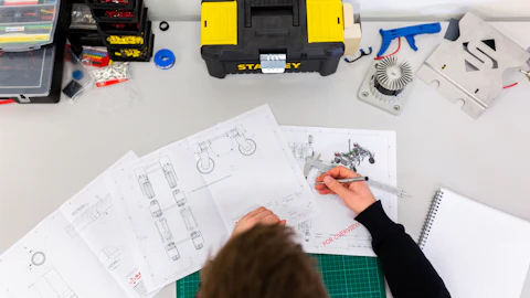 Engineer checking technical drawings with a caliper