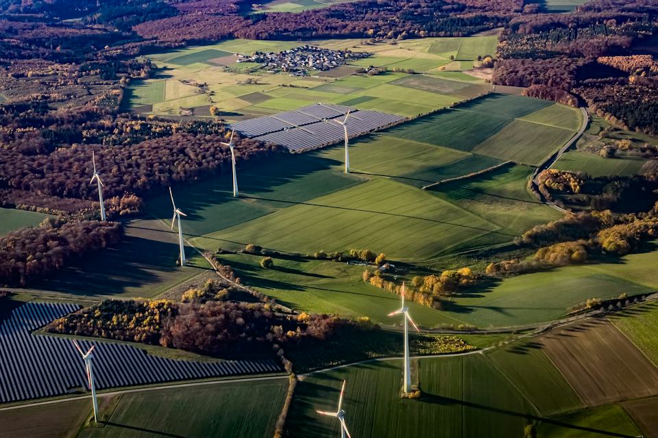 Wind turbines and solar fields across a rural landscape